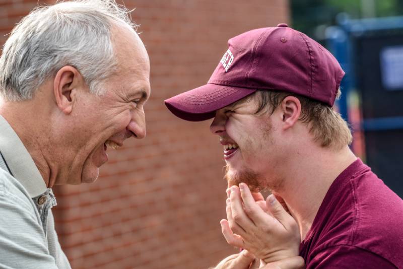 Two men laughing and enjoying their work at a 501c nonprofit