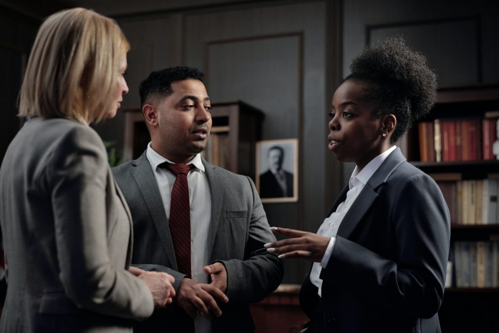 Three people in business suits having a conversation.