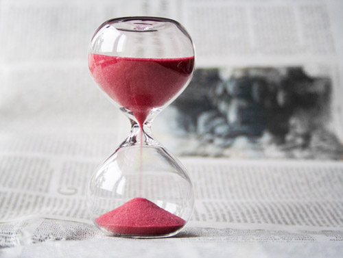 An hourglass with red sand.