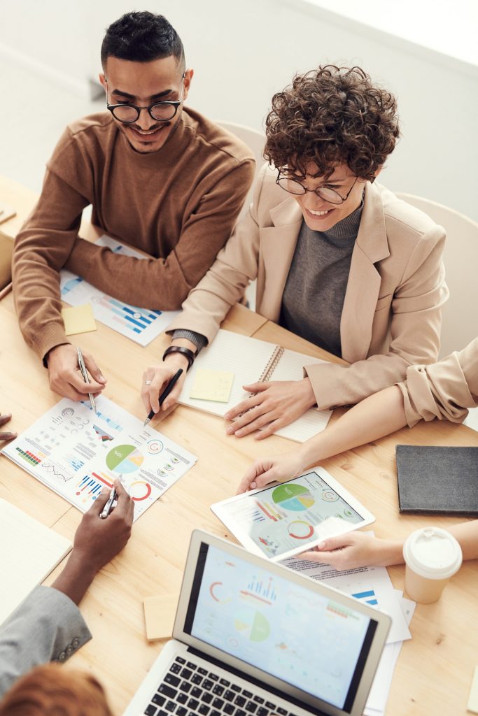 People sit at a table reviewing marketing materials