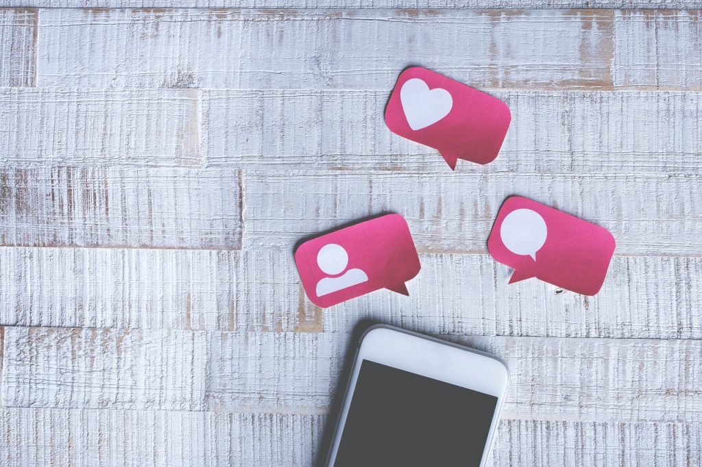 Photo of a smartphone with images of social media likes and followers.