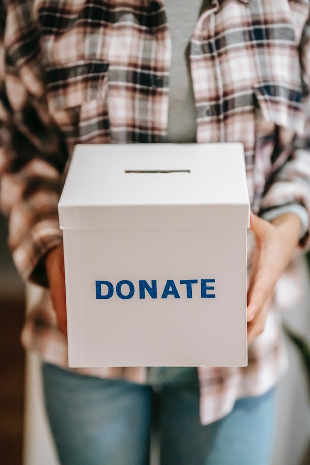 A person holds a donation box for a fundraiser.