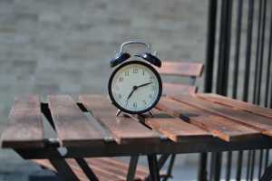 black alarm clock on wooden table