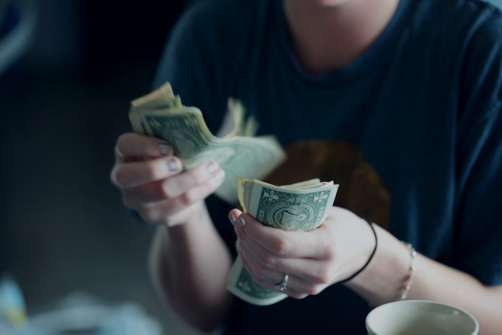 Cropped image of a person holding one dollar bills