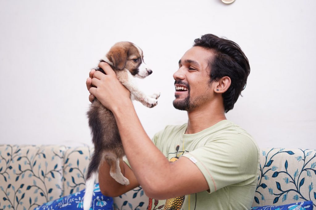 Man smiling at a puppy at an 501c3 nonprofit animal rescue center