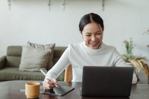 Nonprofit manager smiling as she works on her nonprofit’s crowdfunding campaign