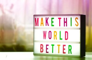 Tabletop sign that reads “Make This World Better”